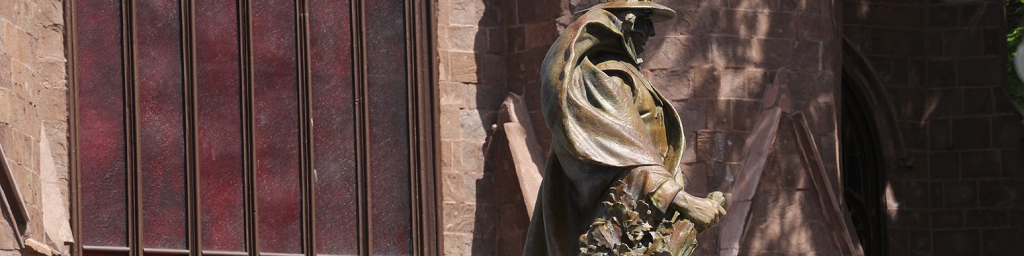 A front view of the Salem Witch Museum with the statue of Roger Conant in the foreground. This image is a backdrop for the FAQ.