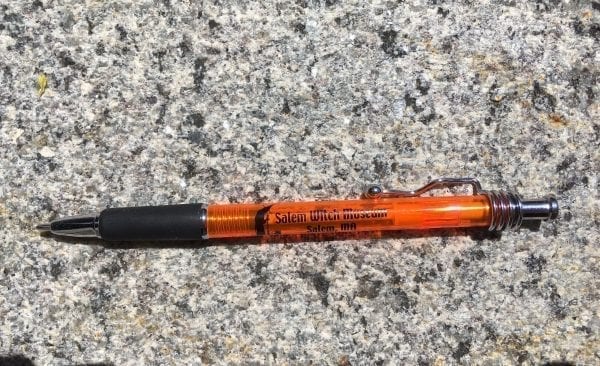 This orange ball-point pen writes with black ink and features the Salem Witch Museum logo. Long-lasting!