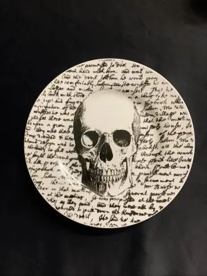 plate with a human skull and old world writing. Also says "Salem 1626" on the plate.