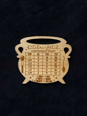 An engraved wooden magnet in the shape of a cauldron. The words "Kitchen Witch Conversion Chart" are across the top. Converts between cups, ounces, tablespoons, and teaspoons, as well as pints, quarts, and gallons.